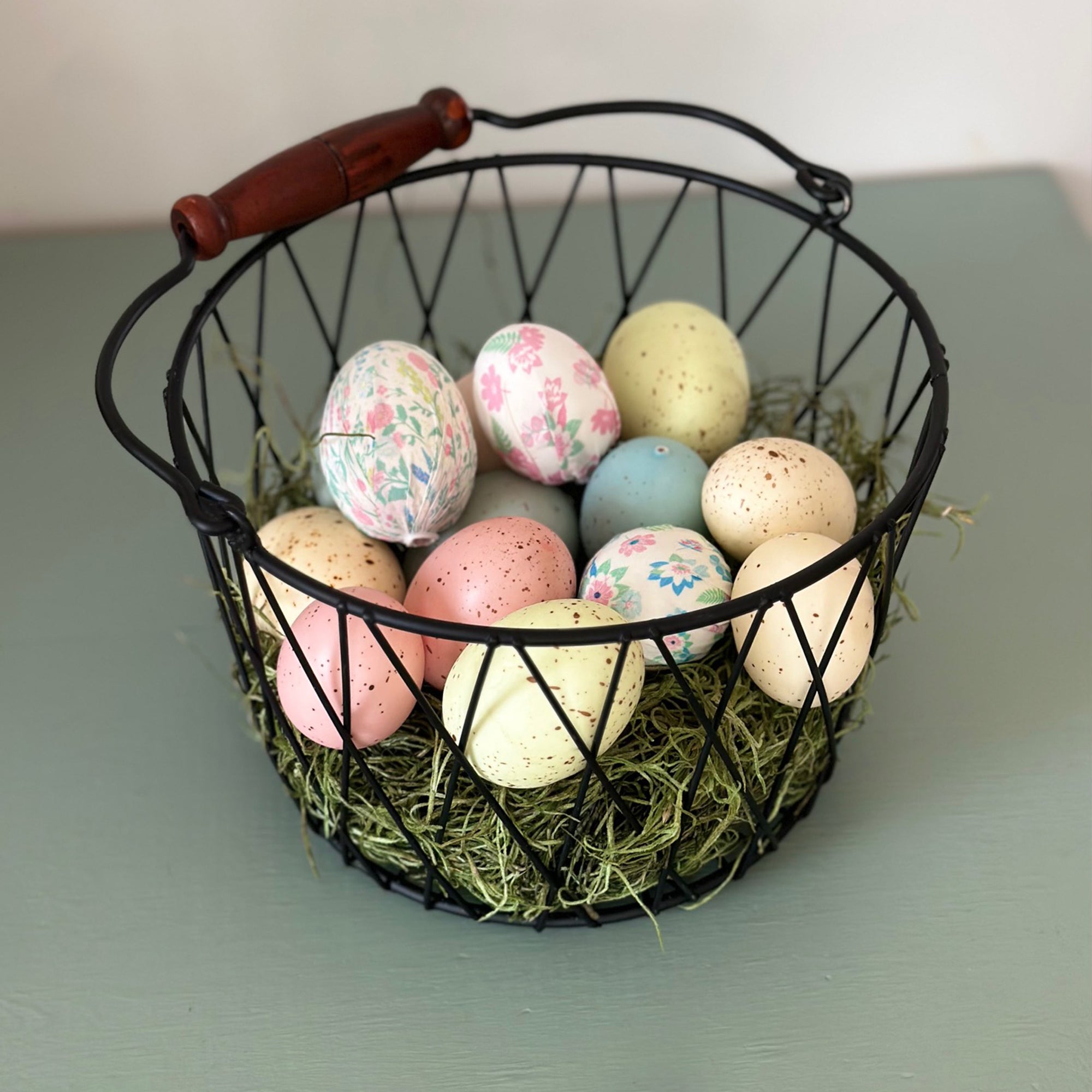 Rustic farmhouse style wire basket with colorful pastel easter eggs inside link to blog post for easter baskets