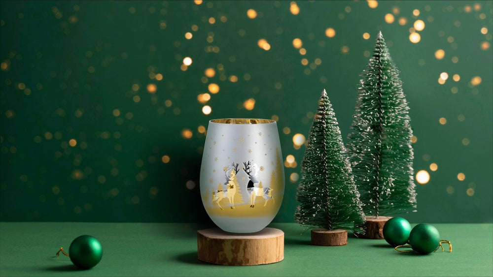 Holiday wine glasses with christmas theme. small christmas trees in background